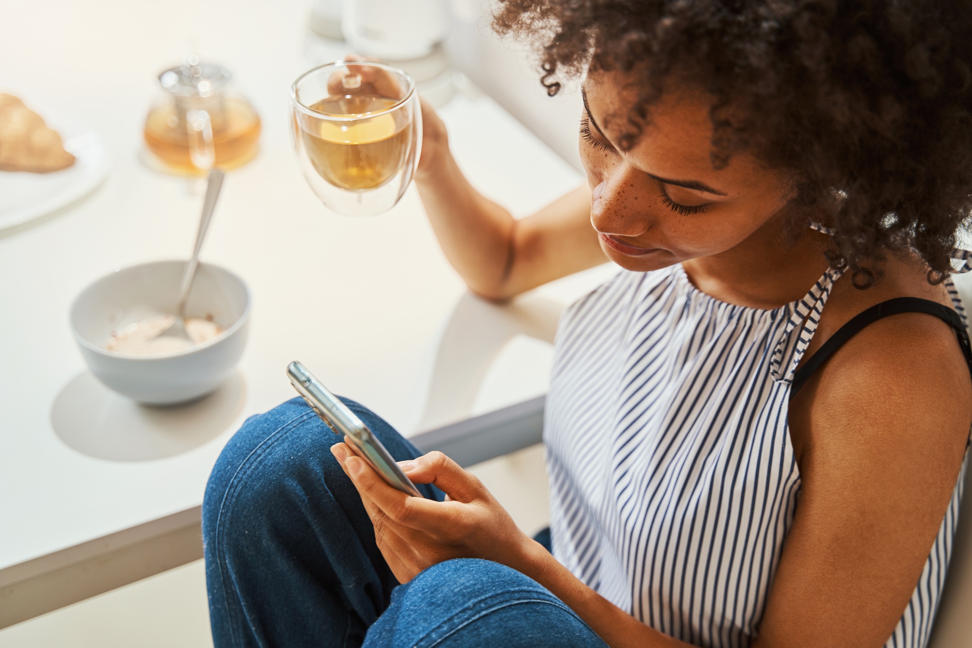 Woman focused on reading a text message at breakfast
