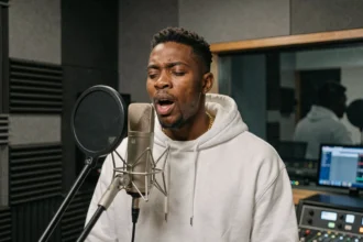 Rappeur Jules en session d'enregistrement dans un studio professionnel, micro condenser au premier plan