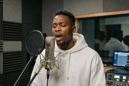 Rappeur Jules en session d'enregistrement dans un studio professionnel, micro condenser au premier plan